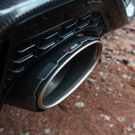 Close-up detail shot of the Akrapovič carbon-fiber/titanium tailpipe, emphasizing the exceptional build quality and advanced materials used.