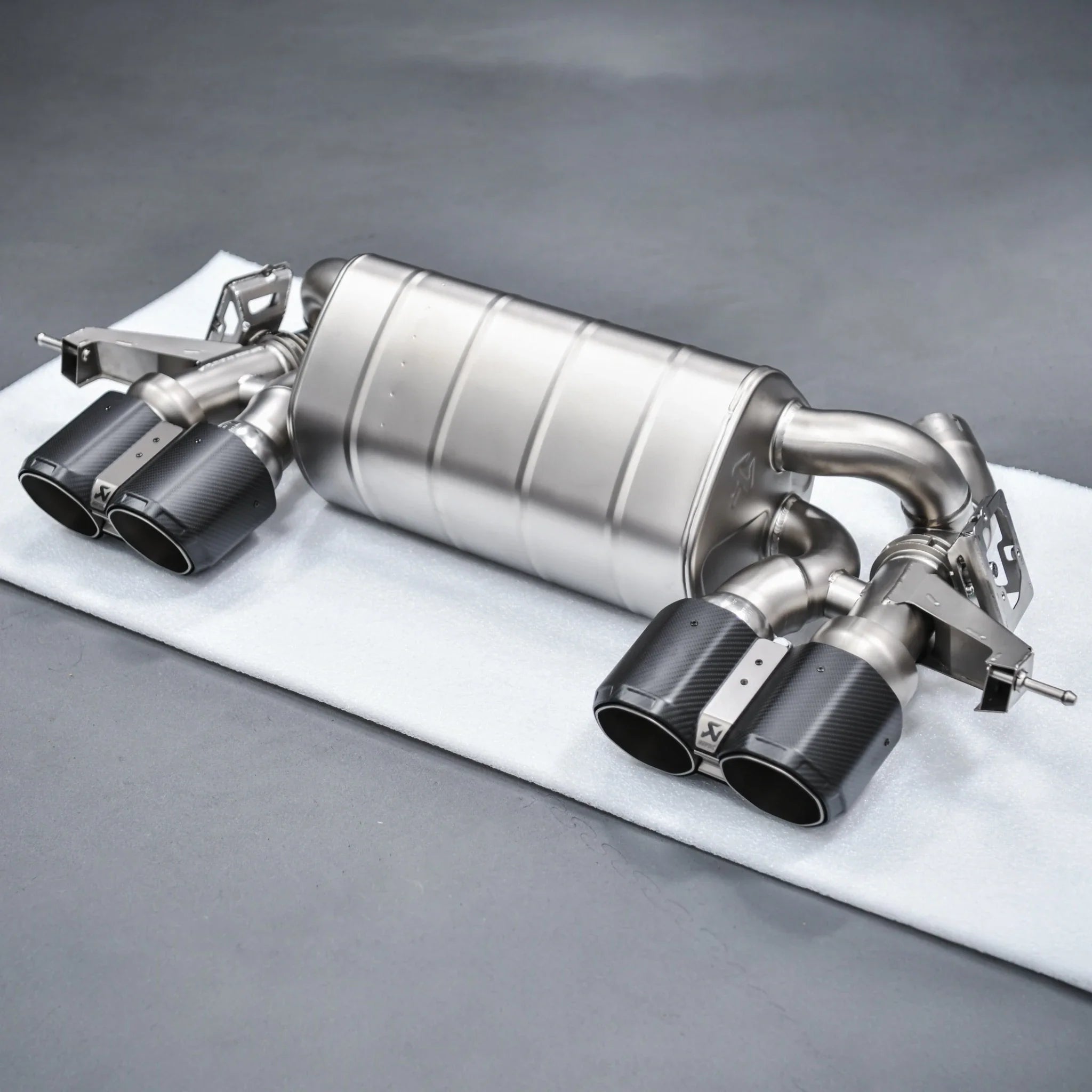 Complete Akrapovic Slip-On Line Titanium Performance Exhaust for BMW M2 G87, displayed at PERON Automotive’s Performance Workshop before installation.