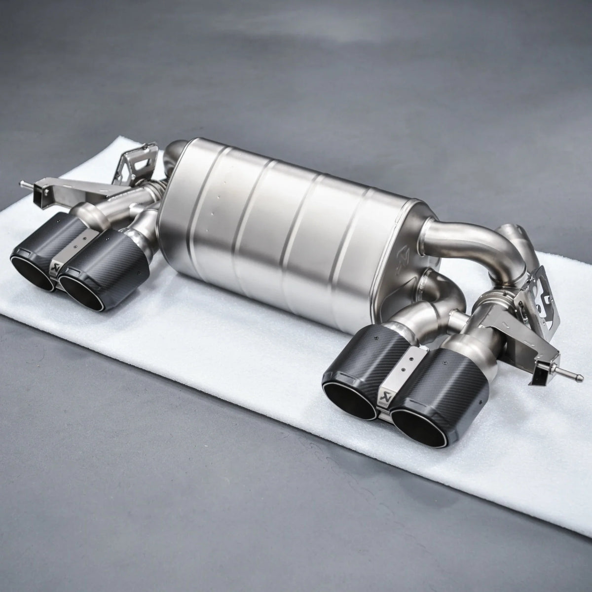 Complete Akrapovic Slip-On Line Titanium Performance Exhaust for BMW M2 G87, displayed at PERON Automotive’s Performance Workshop before installation.
