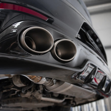 Low-angle shot of the Porsche 911 Turbo S 991.2, highlighting the Akrapovic titanium tailpipes and carbon diffuser installed at PERON Performance.