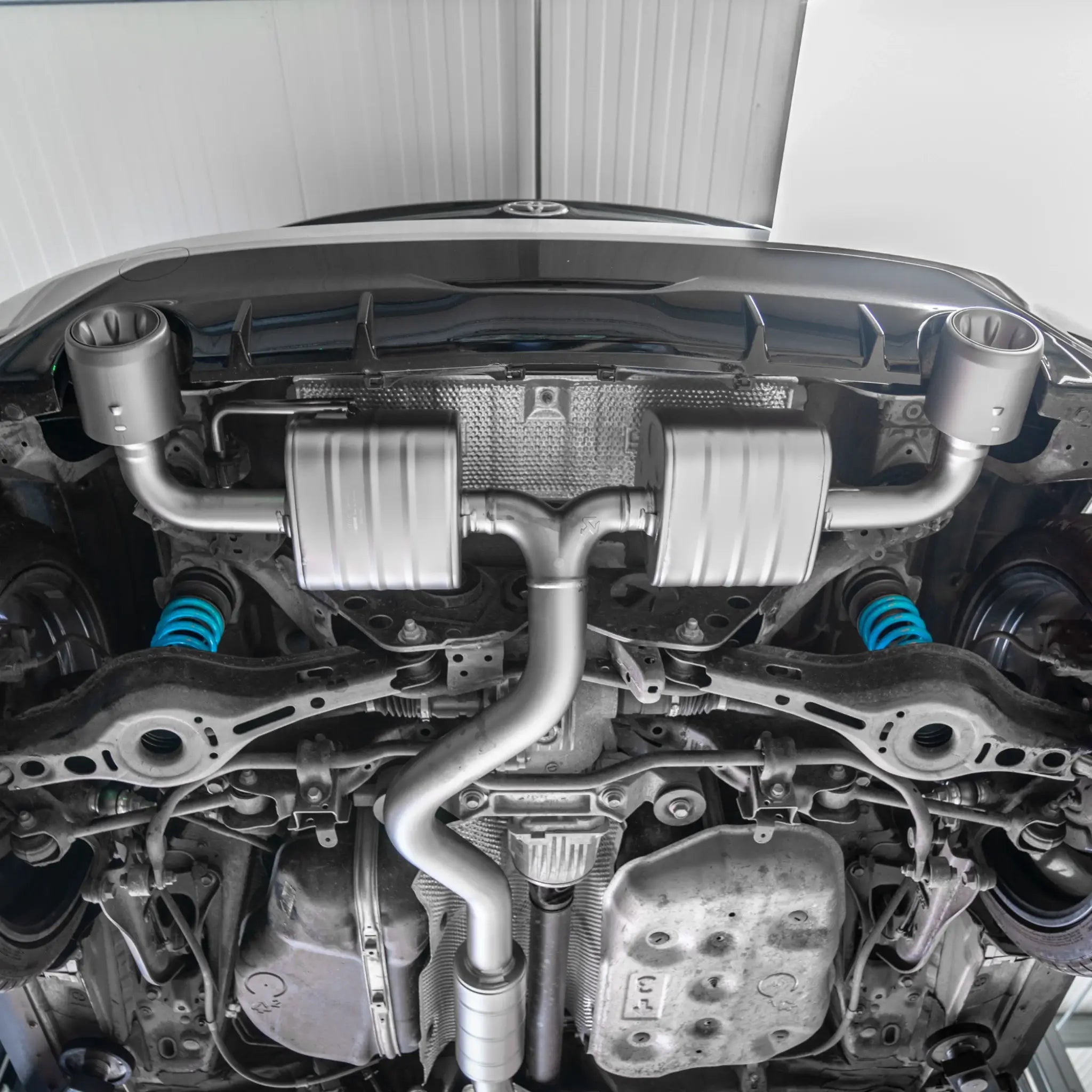 Shot from underneath the Toyota GR Yaris, showcasing the lightweight titanium construction and precise fitment of the Akrapovič Slip-On Race Line (Titanium).