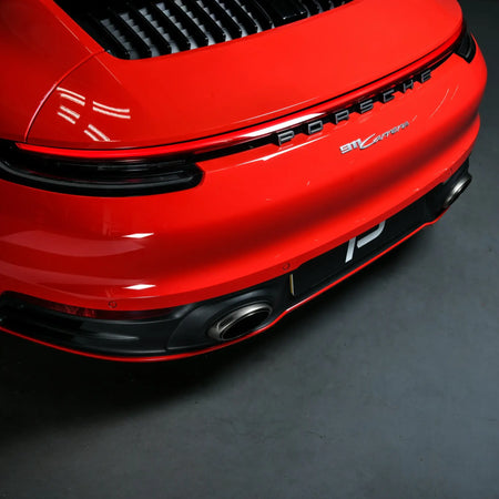 Rear bumper shot highlighting seamless fitment and integration of Akrapovic Slip-On Race Line with Porsche 911 Carrera 992 design lines.