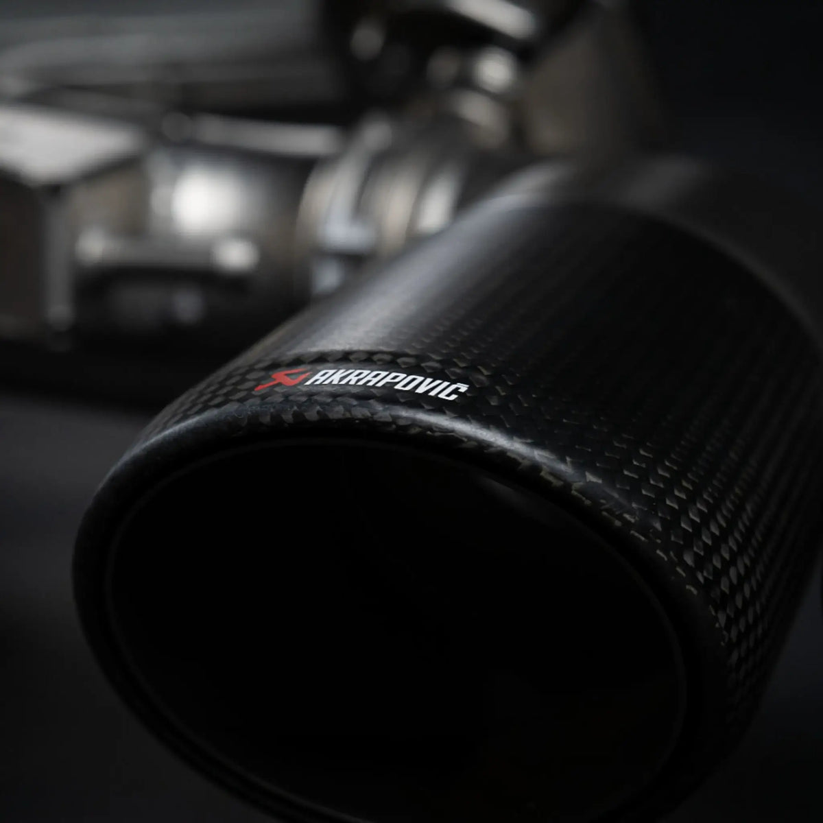 Detailed close-up of the Akrapovic carbon tailpipe, capturing the premium finish of the Evolution Line titanium performance exhaust system on the Porsche Cayenne 536.2.