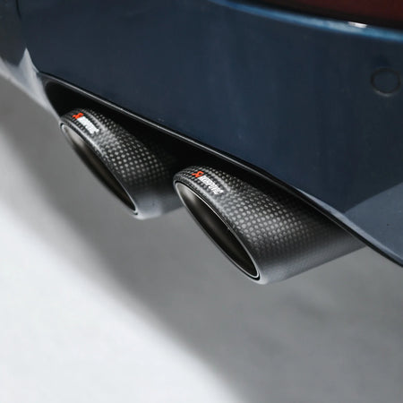 Detail shot of Akrapovic carbon tailpipe installed on Porsche Cayenne 536.2 in PERON Performance Workshop.