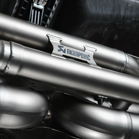 Close-up detail of Akrapovic logo on Slip-On Race Line titanium exhaust system.
