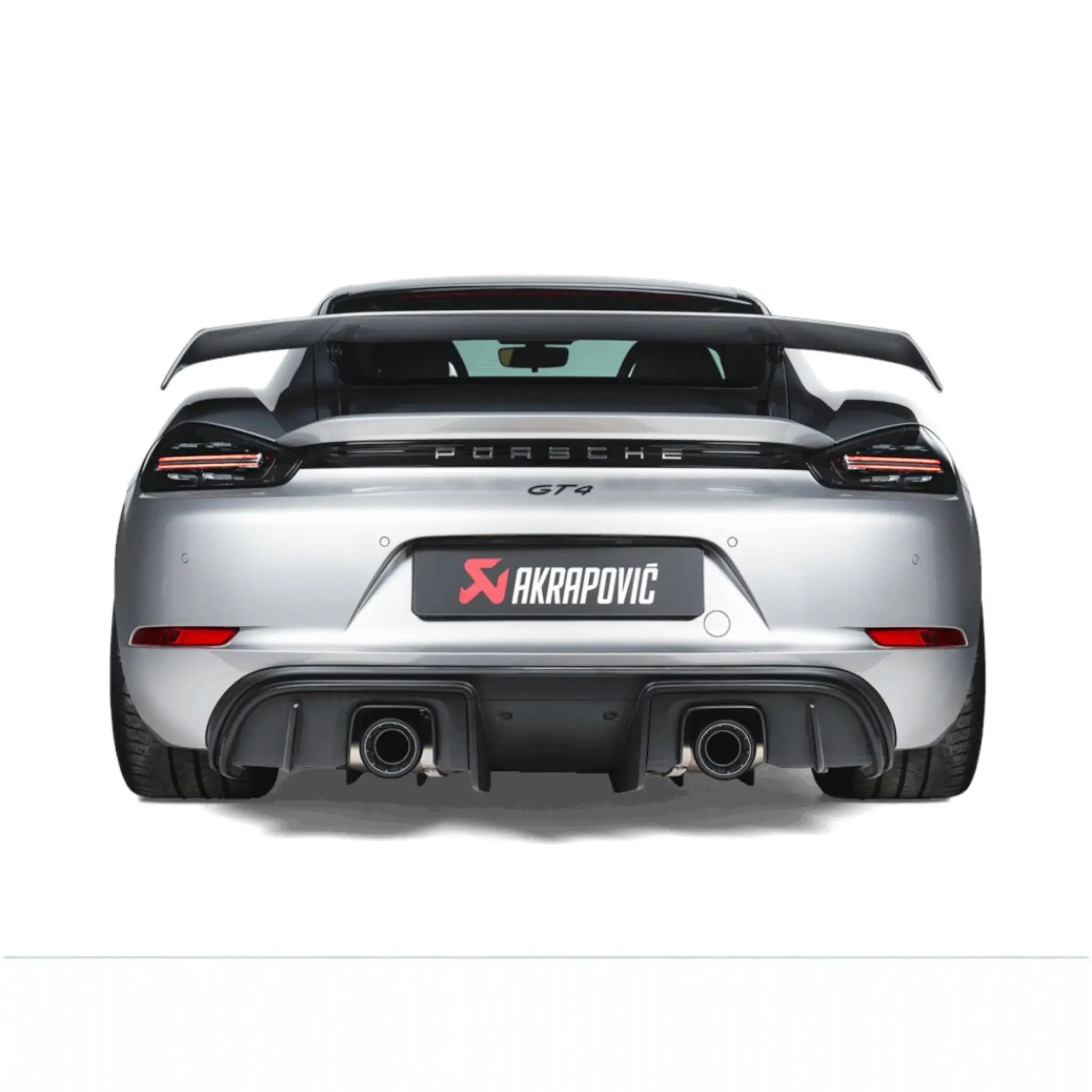 Straight rear view of Porsche 718 Cayman GT4 fitted with the Akrapovič Slip-On Race Line (Titanium), emphasising the sleek titanium tailpipes and precision fitment.