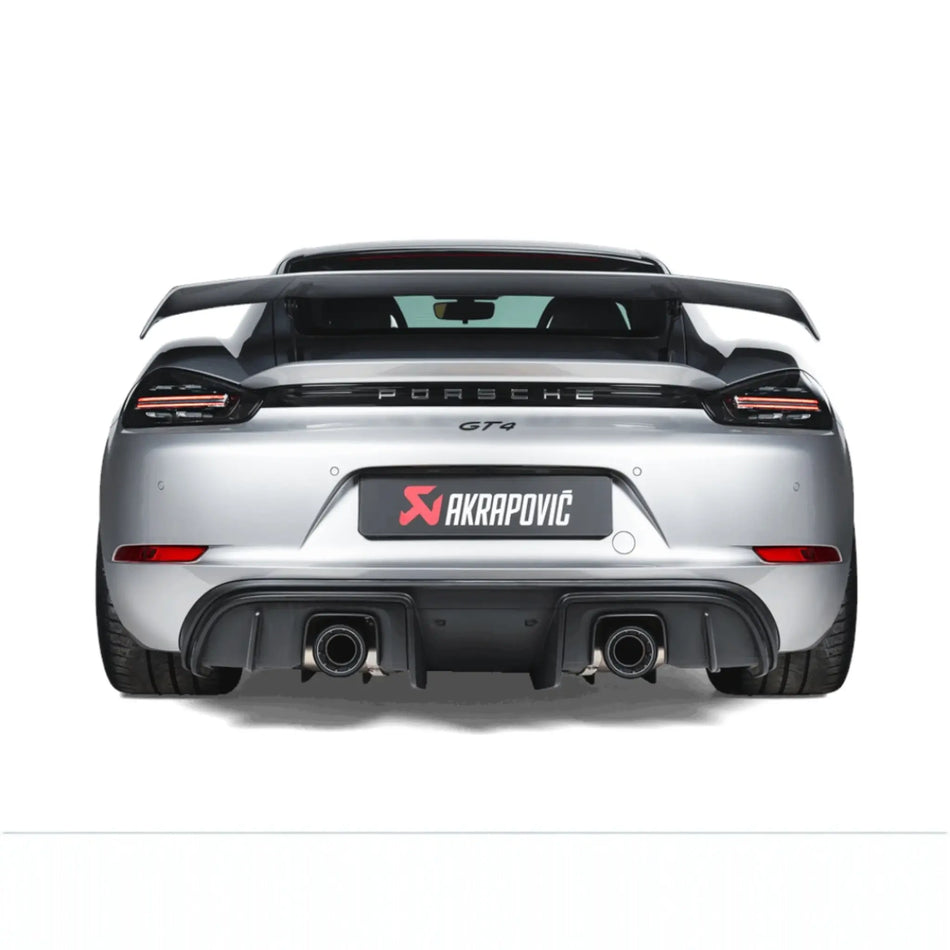 Straight rear view of Porsche 718 Cayman GT4 fitted with the Akrapovič Slip-On Race Line (Titanium), emphasising the sleek titanium tailpipes and precision fitment.